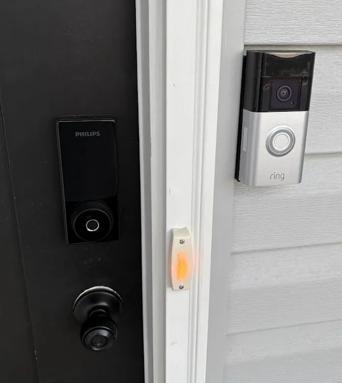 Philips smart deadbolt installed on a front door next to a newly mounted Ring video doorbell