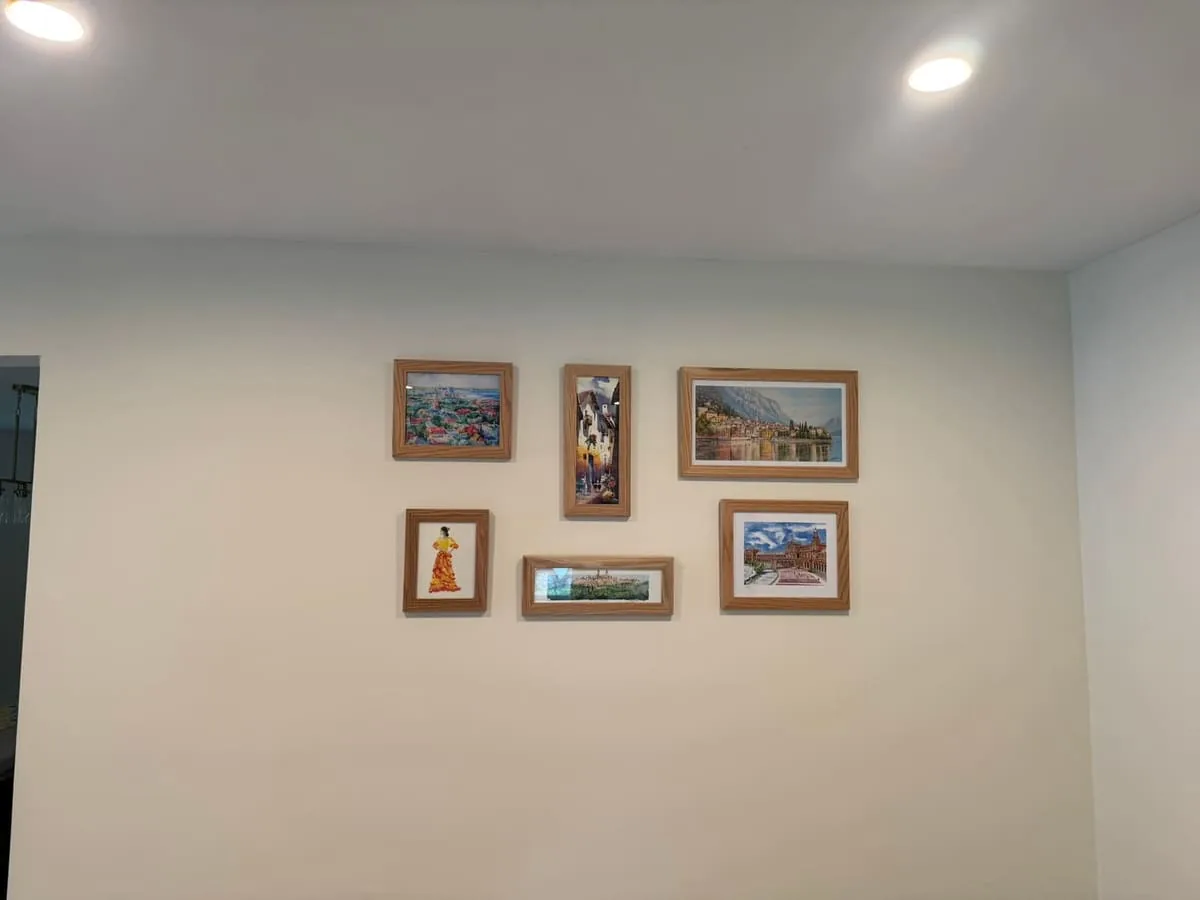 A seven-piece framed art gallery wall, evenly spaced and leveled above a hallway