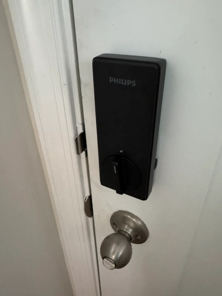 The inside face of the same Philips smart deadbolt, fitted above the door's original knob.